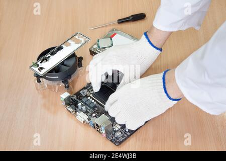 Assemblaggio di un moderno personal computer. Mani di closeup. Tecnologia moderna. Foto Stock