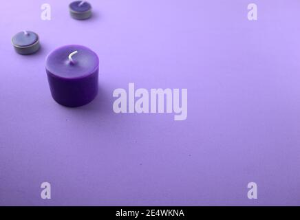 Viola, candele di lavanda sul tavolo. Aromaterapia, spa, massaggi, relax o miglioramento dei concetti psicologici di benessere. Stile minimalista. Foto Stock