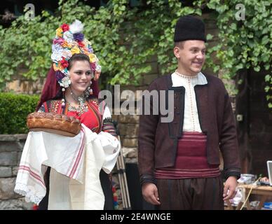 ETAR, Bulgaria - 2 agosto 2011: Giovane coppia fidanzata vestita in tradizionale bulgaro imita il rituale di impegno nell'etnogra-architettonica Foto Stock