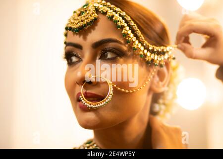 Sposa indiana durante la sessione di trucco Foto Stock