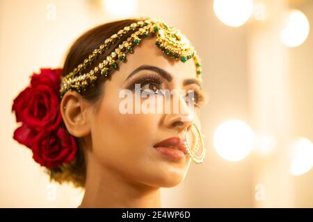 Sposa indiana durante la sessione di trucco Foto Stock