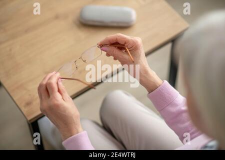 Primo piano immagine delle mani femminili con occhiali Foto Stock