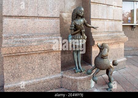 Kiev, Ucraina - 18 aprile 2014: Una scultura di una ragazza dai capelli blu e il suo amico a quattro zampe è stato installato nel 2005 all'ingresso della costruzione di Foto Stock