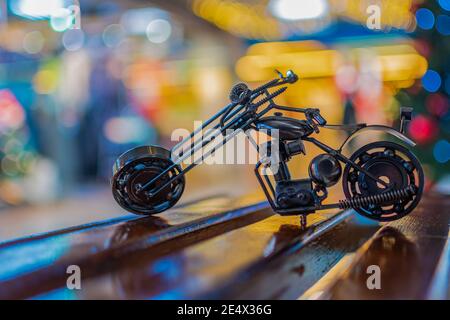 Il modello in bronzo di una moto da strada si erge su un legno superficie Foto Stock