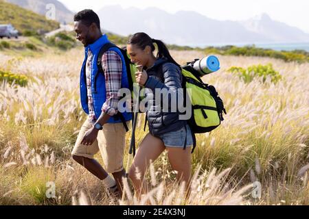 Fit afrcan coppia americana indossare zaini nordic Walking con bastoni in campagna di montagna Foto Stock