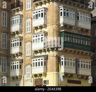 Antico palazzo con i tradizionali balconi di legno chiusi (gallarija) in una strada di Valletta, Malta Foto Stock