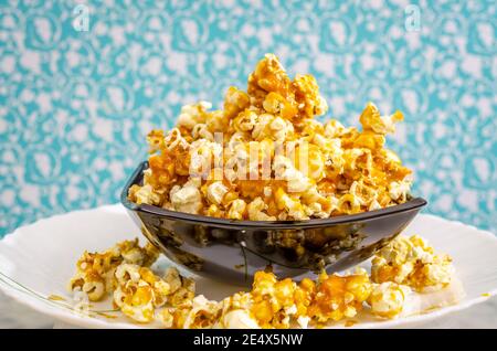 Cumulo di popcorn caramello dolce in una ciotola nera. Foto Stock