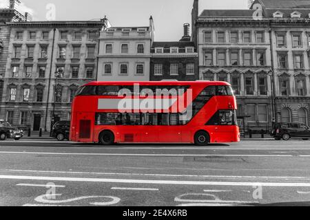 AUTOBUS A due piani ROSSO che scende lungo la strada della città - colore rosso in bianco e nero. Foto Stock