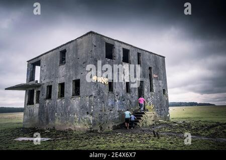 Bambini che entrano nella torre di controllo del derelict sul disusato WW2 RAF Davidstow Airfield su Bodmin Moor in Cornovaglia. Foto Stock