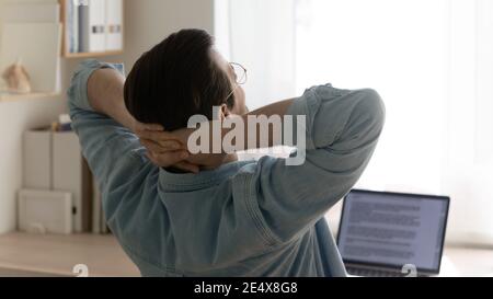 Giovane uomo freelance che prende una breve pausa di lavoro di routine computer Foto Stock