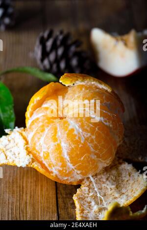 Gustoso mandarino maturo su sfondo di legno. Mandarino fresco sbucciato su tavola di legno. Foto Stock