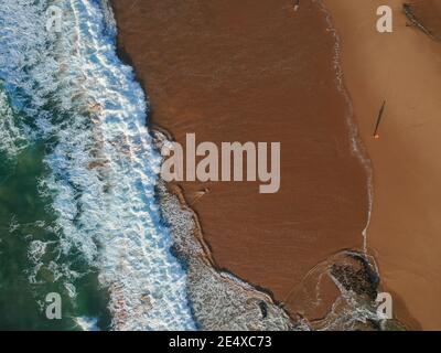 Vista aerea delle onde su una splendida spiaggia di sabbia dell'oceano Foto Stock