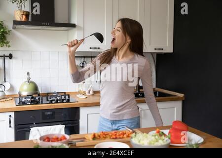 Cuffie per musica, canto e cucina femminile con fragola. Canta, cucina e  donna che fanno uno spuntino con frutta per una sana alimentazione mentre  Foto stock - Alamy