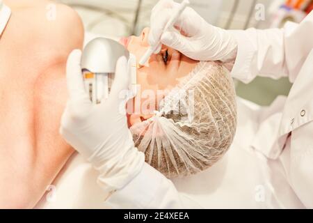 Preparazione per il serraggio della pelle mediante ultrasuoni sul viso di una donna al chirurgo di plastica Foto Stock