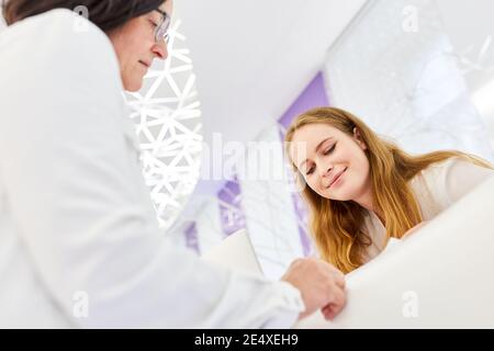 Giovane donna al banco della reception in un salone di bellezza o clinica di bellezza Foto Stock