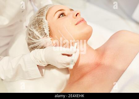 Preparazione alla chirurgia plastica sul viso di una donna con marcatura con penna Foto Stock