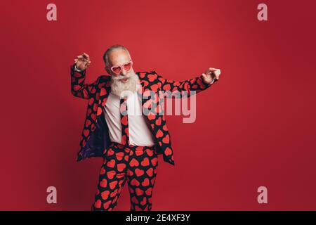 Foto di spensierata funky vecchio stile di danza retrò indossare la tuta da stampa a cuore su sfondo rosso isolato Foto Stock