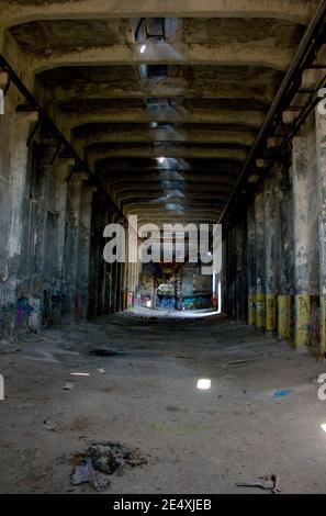 Sala oscura, vuota e grintosa abbandonata di una fabbrica distrutta Foto Stock