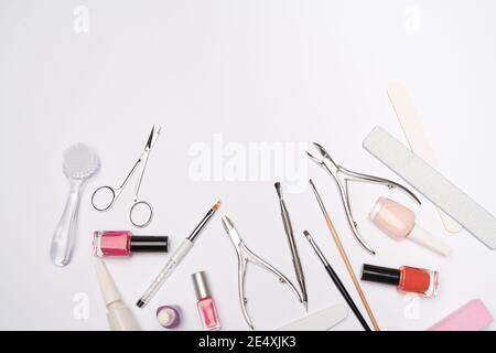 vista dall'alto del set di utensili per manicure per la cura delle unghie su sfondo chiaro: spazzola, forbici, smalto per unghie, lime e pinzette Foto Stock