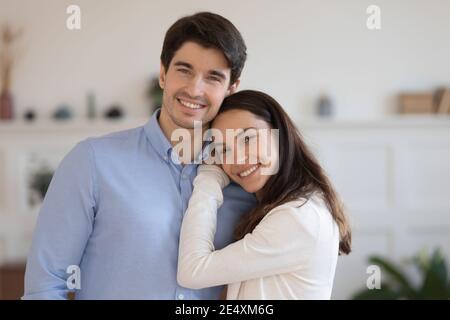 Testa ritratto girato sorridendo uomo e donna abbracciando, in piedi Foto Stock