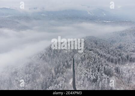 Vista aerea invernale della strada di montagna curvy, in Poiana Brasov Foto Stock