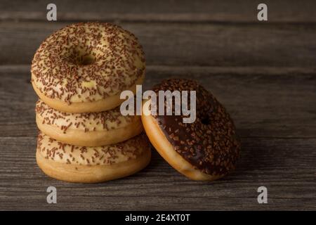 Ciambelle ad anello ricoperte di vaniglia e glassa di cioccolato e cosparse di jimmie. Foto Stock