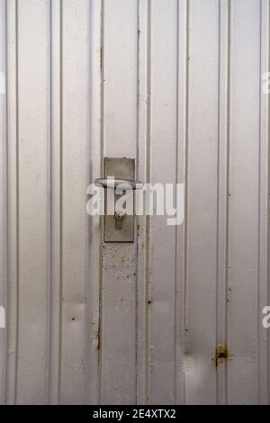 Colpo verticale di macchie arrugginite e un blocco di a. porta del garage Foto Stock