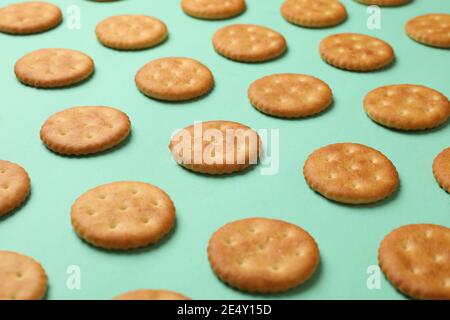 Flat lay con biscotti cracker su uno sfondo di menta, un arrangiamento di snack croccanti in una fresca tavolozza pastello Foto Stock