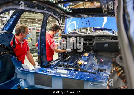 Lipsia, Germania. 07 maggio 2020. I dipendenti Porsche che indossano le protezioni per la bocca lavorano su un Macan durante l'assemblaggio. A Lipsia si applicano ora norme igieniche rigorose. Ad esempio, i dipendenti della produzione e della mensa dovrebbero indossare una protezione per il naso. Si applica una distanza minima di 1.5 metri. Inoltre, la pulizia viene eseguita con maggiore frequenza rispetto a prima. Credit: Jan Woitas/dpa-Zentralbild/dpa/Alamy Live News Foto Stock