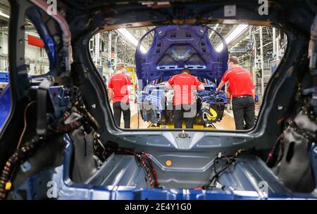 Lipsia, Germania. 07 maggio 2020. I dipendenti Porsche che indossano le protezioni per la bocca lavorano su un Macan durante l'assemblaggio. A Lipsia si applicano ora norme igieniche rigorose. Ad esempio, i dipendenti della produzione e della mensa dovrebbero indossare una protezione per il naso. Si applica una distanza minima di 1.5 metri. Inoltre, la pulizia viene eseguita con maggiore frequenza rispetto a prima. Credit: Jan Woitas/dpa-Zentralbild/dpa/Alamy Live News Foto Stock