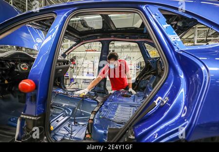 Lipsia, Germania. 07 maggio 2020. Un dipendente Porsche indossa una protezione per la bocca mentre lavora su un Macan durante l'assemblaggio. A Lipsia si applicano ora norme igieniche rigorose. Ad esempio, i dipendenti della produzione e della mensa dovrebbero indossare una protezione per il naso. Si applica una distanza minima di 1.5 metri. Inoltre, la pulizia viene eseguita con maggiore frequenza rispetto a prima. Credit: Jan Woitas/dpa-Zentralbild/dpa/Alamy Live News Foto Stock