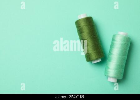 Filo da cucire su sfondo menta, spazio per il testo Foto Stock