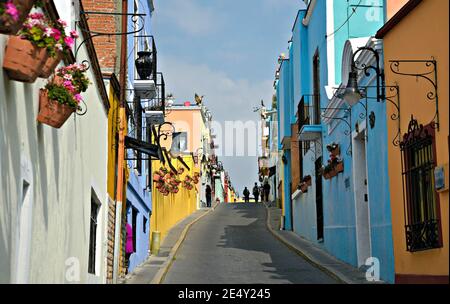 Case coloniali con pareti colorate in stucco e vasi di argilla fatti a mano con fiori lungo la Calzada de 16 de Septiembre.in Atlixco, Puebla Messico Foto Stock