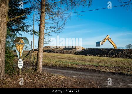 'Gott Schütze unsere Fluren' Kreuz mit Inschrift neben Supermarktneubau im ländlichen Raum Foto Stock