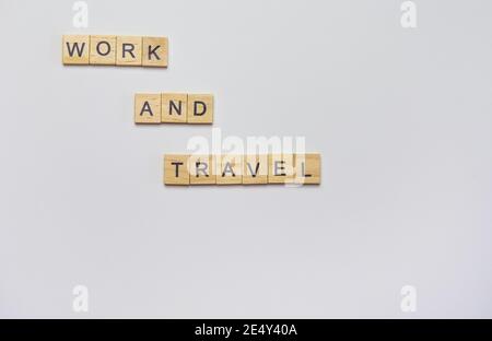 Iscrizione in legno da cubetti - lavoro e viaggio su sfondo bianco, vista dall'alto Foto Stock