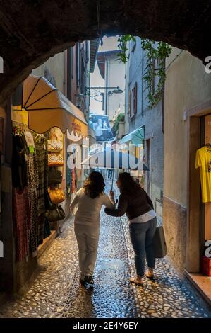 Signore shopping in una stradina a Malcesine, sulla sponda orientale del Lago di Garda, in Veneto. Foto Stock