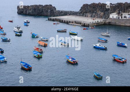 molte barche colorate di pescatori nell'acqua dell'oceano vicino a. porto durante una fredda mattina Foto Stock
