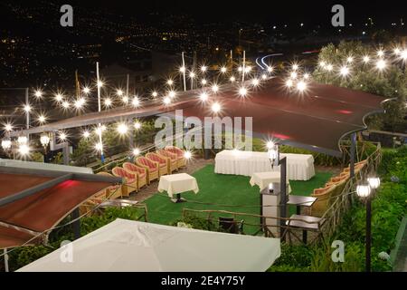 Locale ristorante preparato per un ricevimento di nozze di notte con luci multiple Foto Stock
