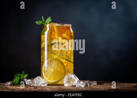 Bevanda estiva tè freddo con fette di limone e menta sfondo scuro Foto Stock