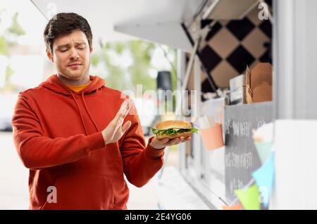 giovane uomo che rifiuta da hamburger a camion di cibo Foto Stock