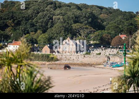 St Brelades Bay Church sul canale isola di Jersey vacanza alba all'alba, splendido cielo blu, splendida spiaggia sabbiosa nelle nuvole del mattino Foto Stock