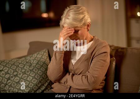 donna anziana infelice che soffre di mal di testa Foto Stock