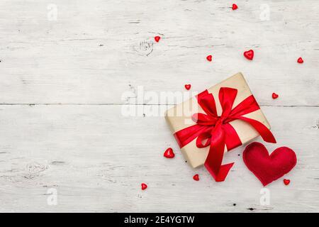 Sfondo del biglietto d'auguri di San Valentino con scatole regalo, nastri rossi e cuori assortiti. Vecchio sfondo di legno bianco. Concetto di matrimonio o compleanno, Foto Stock