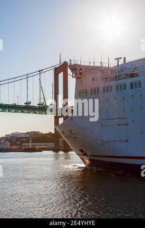 La nave passeggeri è in viaggio sotto un ponte in controluce Foto Stock