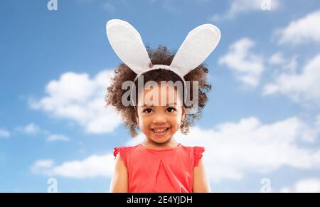 Felice bambina indossa coniglietto pasquale per le orecchie Foto Stock