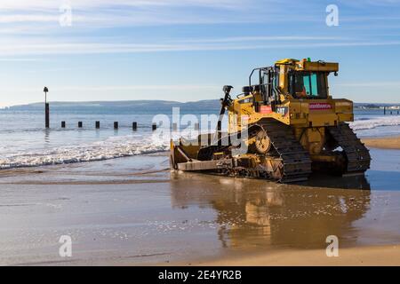 Cat D6T LGP bulldozer crawler caterpillar - programma di rinnovo dei groyne in legno che si svolge sulla spiaggia ad Alum Chine, Bournemouth, Dorset UK a gennaio Foto Stock