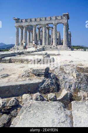 1986 Grecia Tempio di Afaia Aegina il Tempio di Afaia o Afea si trova all'interno di un complesso santuario dedicato alla dea Afaia sull'isola greca di Aegina nel Golfo Saronico. Precedentemente conosciuto come il Tempio di Giove Panhellenius, il tempio dorico è ora riconosciuto come dedicato alla dea madre Aphaia, turisti in un tour guidato godendo la vista del Tempio greco, Aegina Grecia Europa Foto Stock