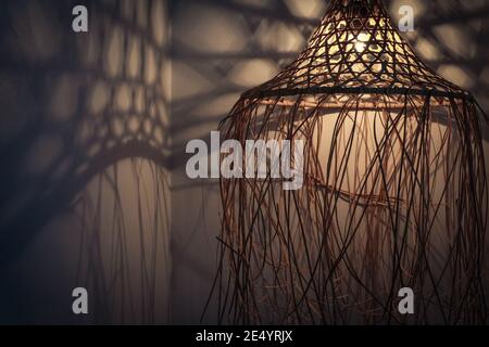 Lampada di bambù in stile boho moderno, tropicale, bohémien con ombre sulle pareti Foto Stock