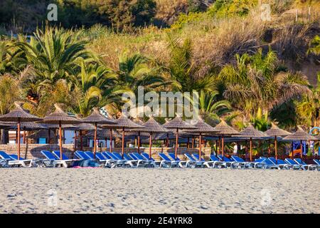 Playa de la Calahonda spiaggia sabbiosa con sdraio e ombrelloni a Nerja, località turistica della Spagna meridionale Foto Stock