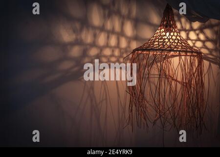 Lampada di bambù in stile boho moderno, tropicale, bohémien con ombre sulle pareti Foto Stock
